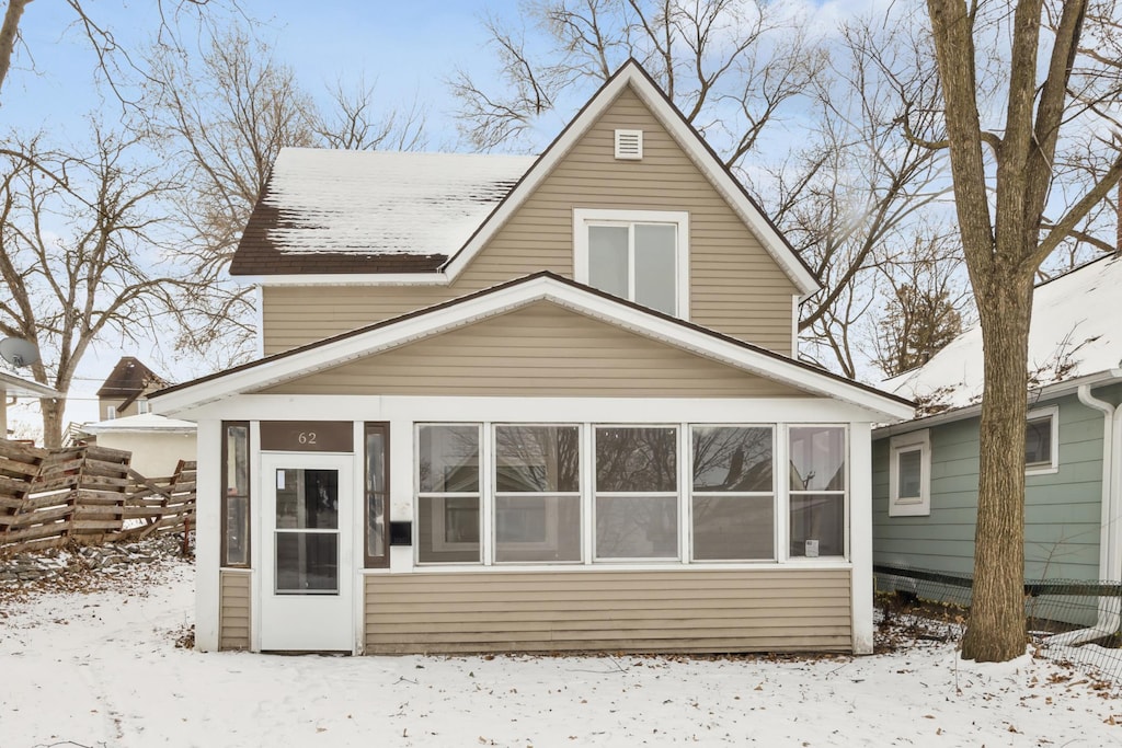 snow covered property featuring a sunroom