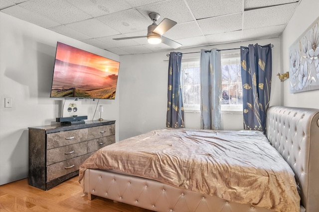 bedroom featuring a paneled ceiling, a ceiling fan, and wood finished floors