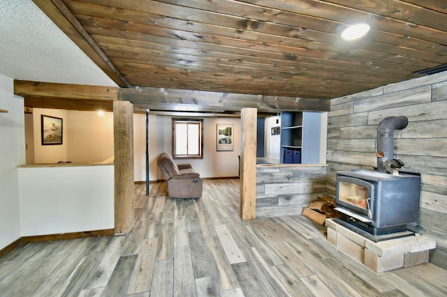 below grade area with a wood stove, wooden ceiling, wooden walls, and wood finished floors