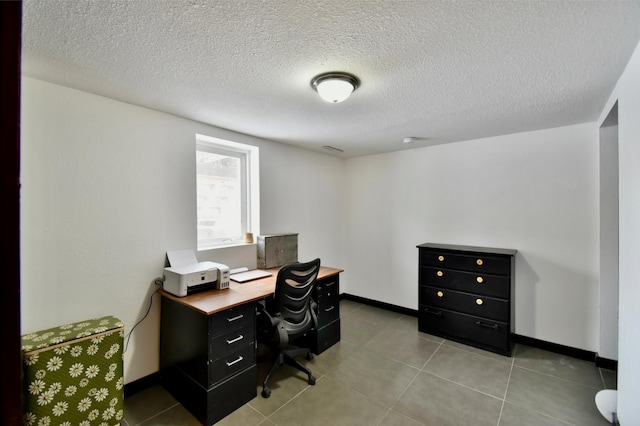 office space with a textured ceiling, baseboards, and light tile patterned floors