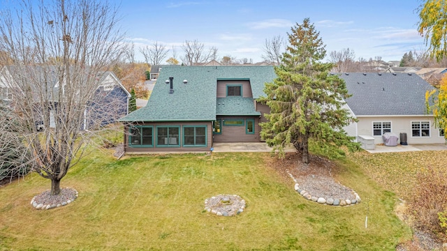 back of house featuring a lawn and a patio area