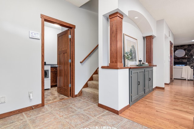 corridor featuring ornate columns and light hardwood / wood-style floors