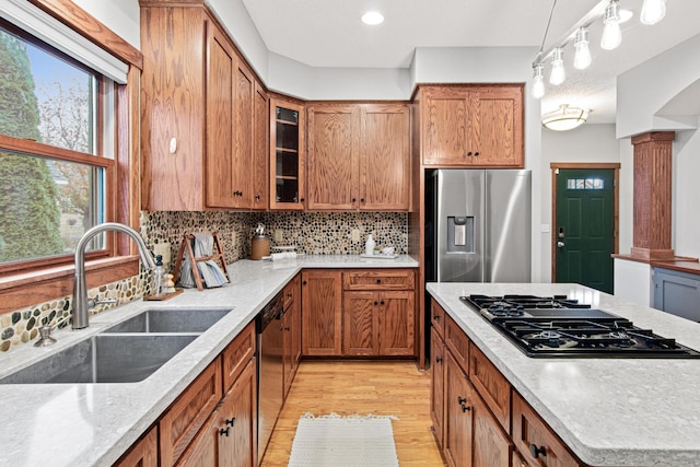 kitchen with sink, appliances with stainless steel finishes, tasteful backsplash, decorative light fixtures, and ornate columns