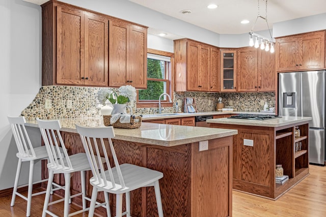 kitchen with appliances with stainless steel finishes, a center island, sink, and a breakfast bar area