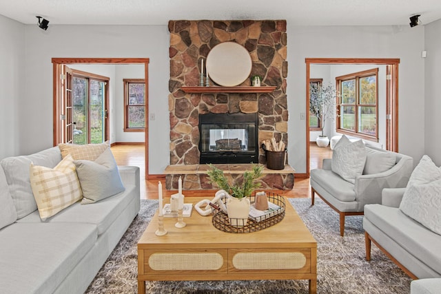 living room with hardwood / wood-style floors, a fireplace, and a textured ceiling