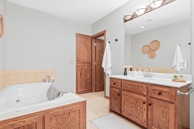 bathroom with vanity, a washtub, tile patterned floors, and a textured ceiling