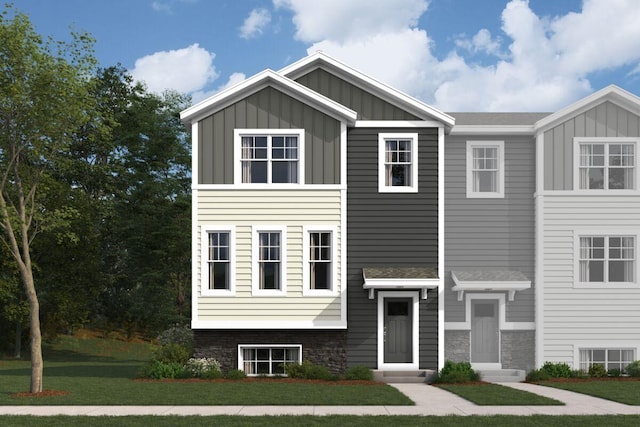 view of front of house featuring entry steps, stone siding, a front lawn, and board and batten siding