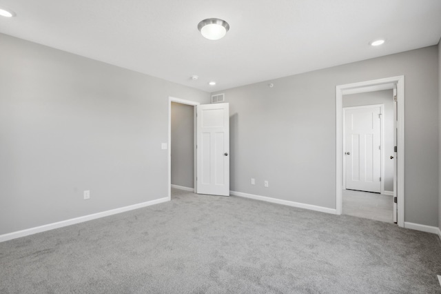 unfurnished bedroom with light colored carpet, visible vents, baseboards, and recessed lighting