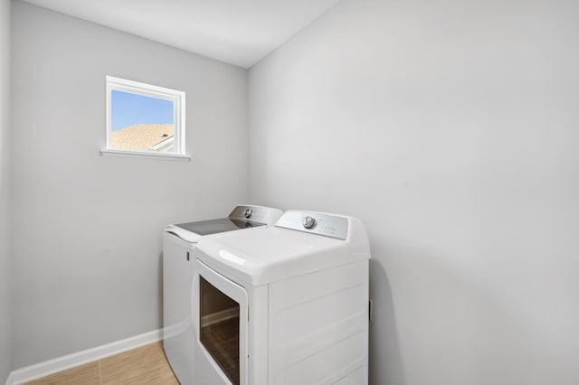 clothes washing area featuring laundry area, baseboards, light wood finished floors, and independent washer and dryer