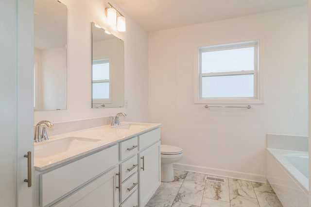 bathroom featuring vanity, a bath, and toilet