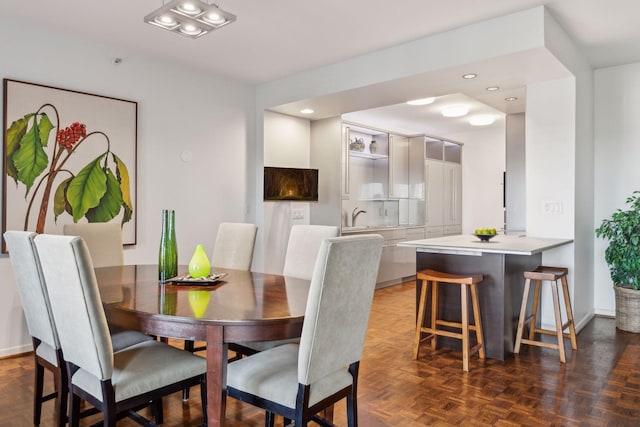 dining space with sink and dark parquet floors