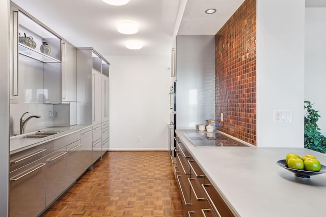 kitchen featuring tasteful backsplash, sink, black electric stovetop, and dark parquet floors