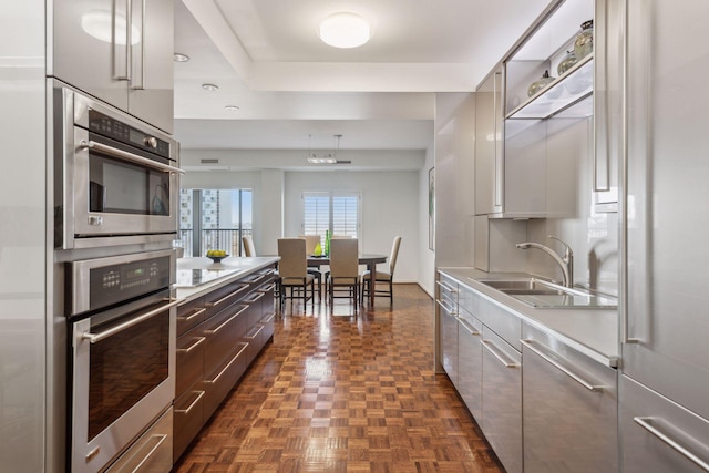 kitchen featuring white cabinetry, a tray ceiling, sink, and dark parquet floors