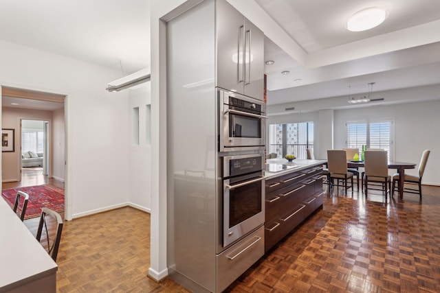 kitchen with black electric cooktop, dark parquet floors, and stainless steel oven