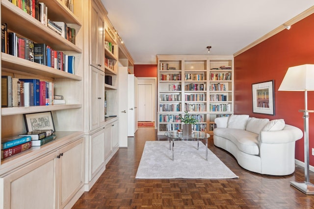 living area featuring ornamental molding, built in features, and dark parquet floors