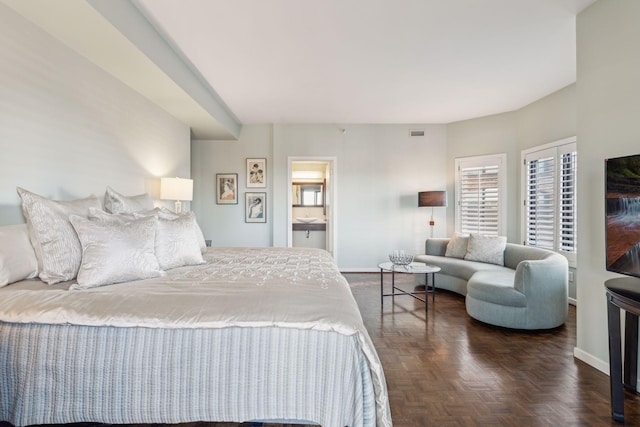 bedroom with ensuite bath and dark parquet floors