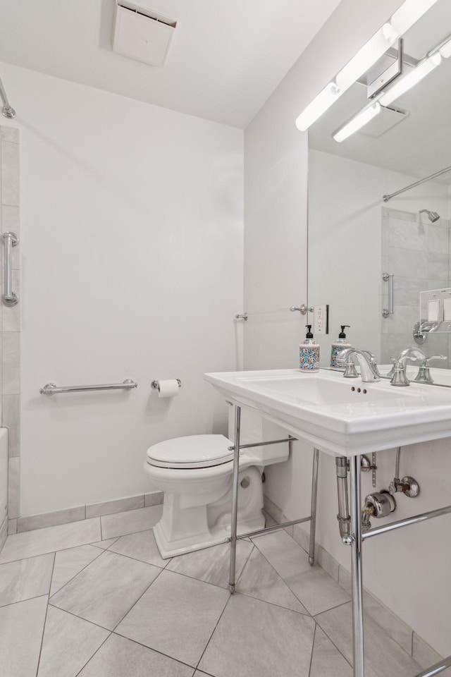 bathroom featuring a tile shower and toilet