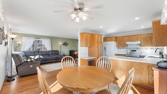 dining space featuring light wood finished floors, a ceiling fan, and recessed lighting