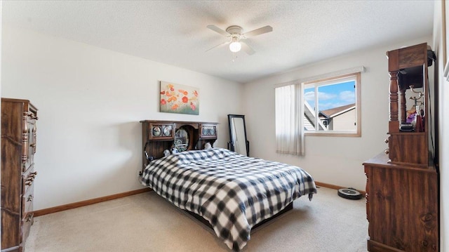 bedroom with light carpet, ceiling fan, baseboards, and a textured ceiling