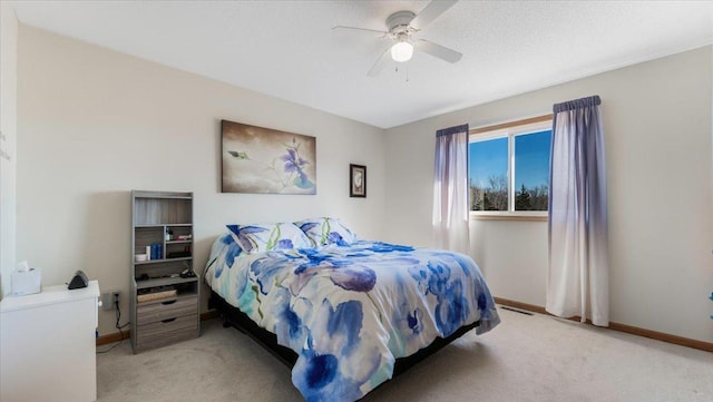 bedroom featuring light colored carpet, ceiling fan, visible vents, and baseboards