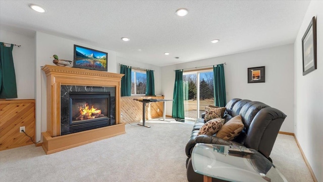 living area featuring a textured ceiling, carpet flooring, and a high end fireplace