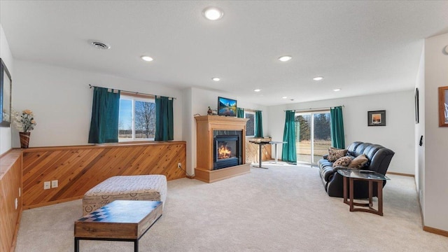 living room with recessed lighting, visible vents, a multi sided fireplace, and light colored carpet