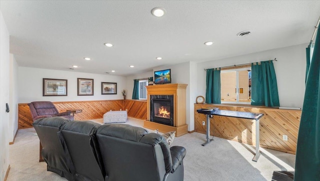 living room with light carpet, wooden walls, a wealth of natural light, and wainscoting