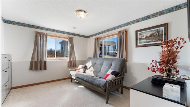 living area featuring baseboards, a healthy amount of sunlight, and light colored carpet