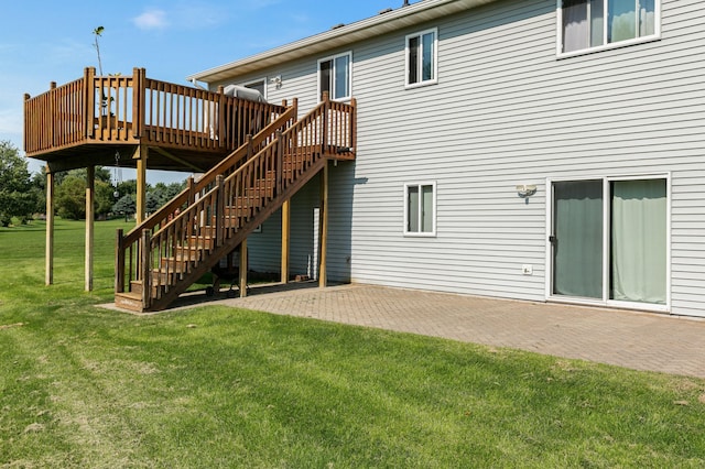 back of property with stairs, a yard, a wooden deck, and a patio