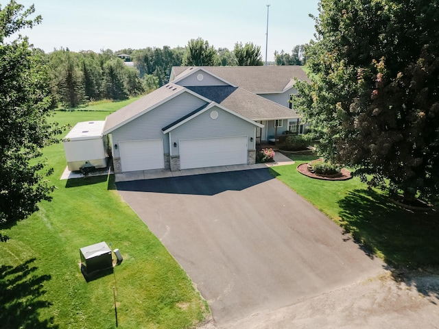 view of front of property featuring a garage, stone siding, aphalt driveway, and a front lawn