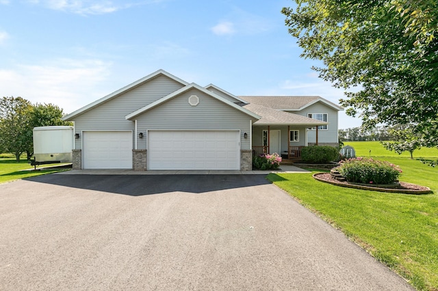 view of front of home featuring a garage, a front yard, a porch, and aphalt driveway