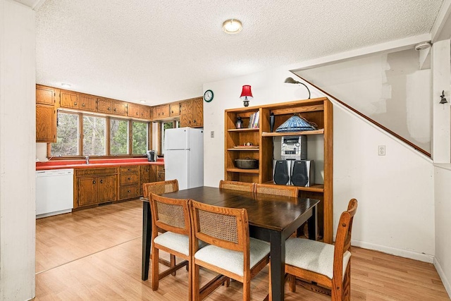 dining room featuring a textured ceiling and light wood-style flooring