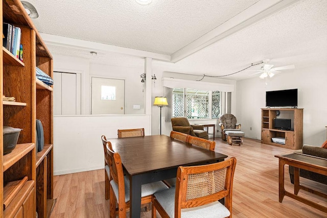 dining area featuring a textured ceiling, ceiling fan, and light wood finished floors
