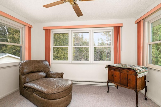 living area featuring a healthy amount of sunlight, a ceiling fan, and carpet flooring