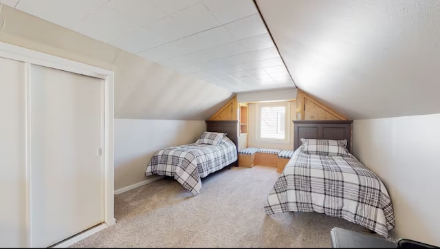 carpeted bedroom featuring vaulted ceiling and a closet