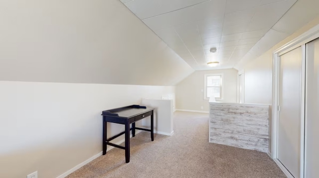 bonus room with vaulted ceiling and light colored carpet