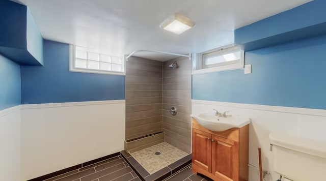 bathroom featuring tiled shower, vanity, and toilet