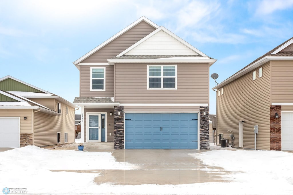 view of front of home featuring a garage and central AC unit