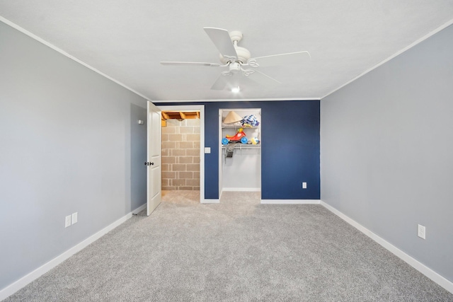 unfurnished bedroom with carpet floors, baseboards, a spacious closet, and ornamental molding