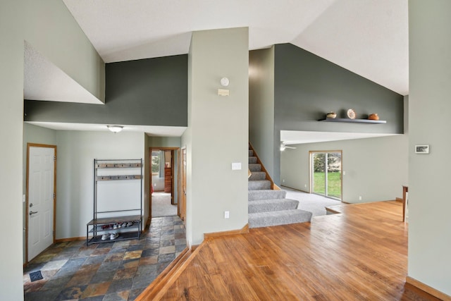 foyer with stairway, high vaulted ceiling, and baseboards