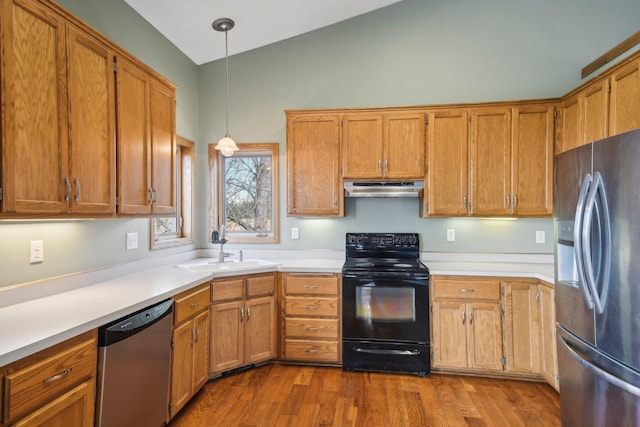 kitchen featuring a sink, light countertops, stainless steel appliances, under cabinet range hood, and pendant lighting