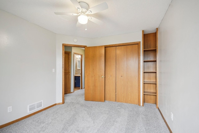 unfurnished bedroom with visible vents, carpet, baseboards, and a closet