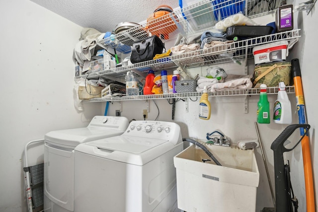 clothes washing area with washer and dryer, laundry area, and a sink