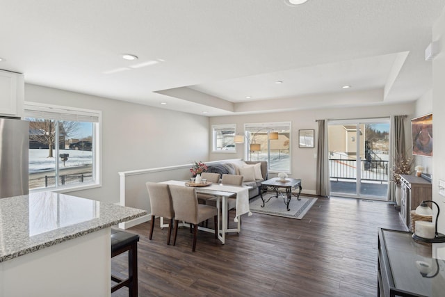 living room featuring dark wood-style floors, a tray ceiling, and recessed lighting