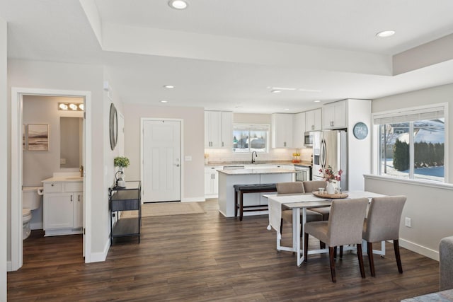 dining area with dark wood-type flooring, recessed lighting, and baseboards