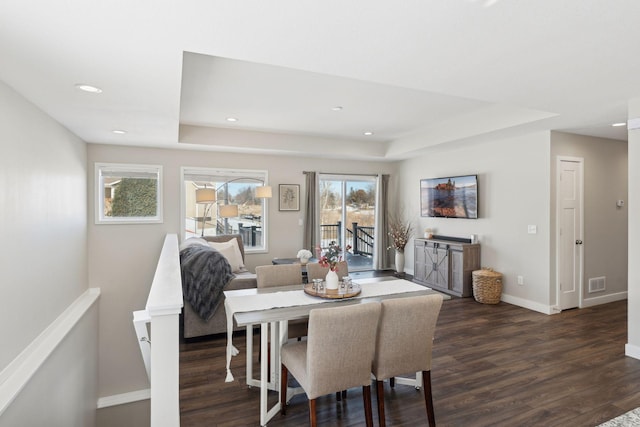 dining area featuring recessed lighting, dark wood-type flooring, visible vents, baseboards, and a raised ceiling