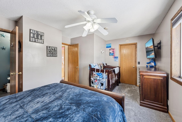 carpeted bedroom with ceiling fan and a textured ceiling