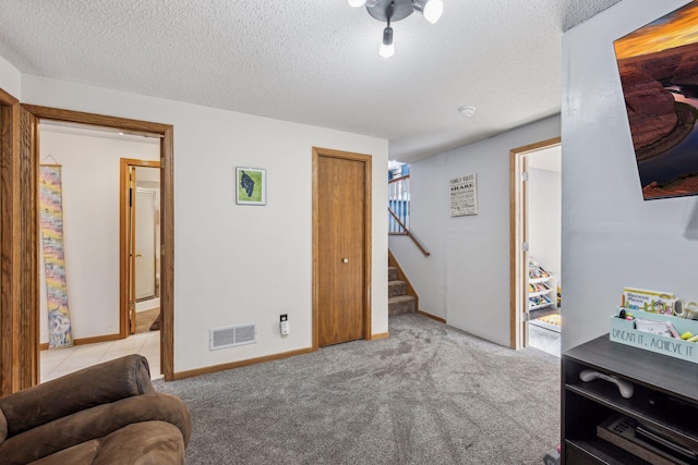 living area with light carpet and a textured ceiling