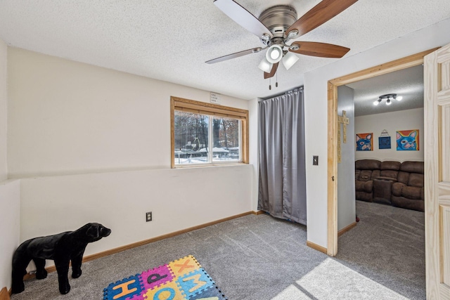 carpeted bedroom featuring ceiling fan and a textured ceiling