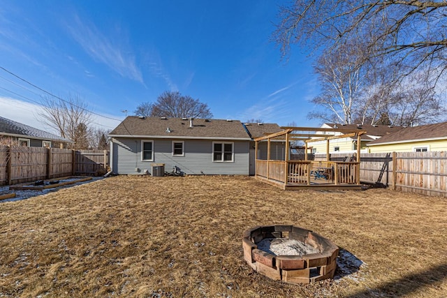 back of property with a wooden deck, an outdoor fire pit, and cooling unit